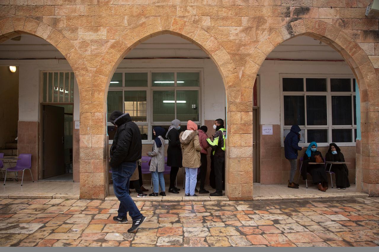 Palestinians wait to receive the Pfizer-BioNTech Covid-19 vaccine during a one-day clinic at a school near the Al Aqsa Mosque compound to vaccinate worshippers following Friday prayers in Jerusalem, Feb 19. Photo: AP