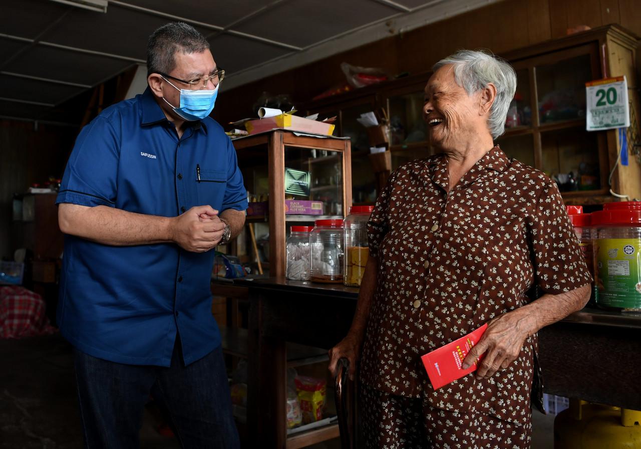 Menteri Komunikasi dan Multimedia Saifuddin Abdullah (kiri) yang juga Ahli Parlimen Indera Mahkota beramah mesra dengan warga emas See Kin Kian, 94, pada majlis Sumbangan Bakul Makanan kepada Komuniti Cina B40 di Kampung Pelindung Beserah hari ini. Gambar: Bernama
