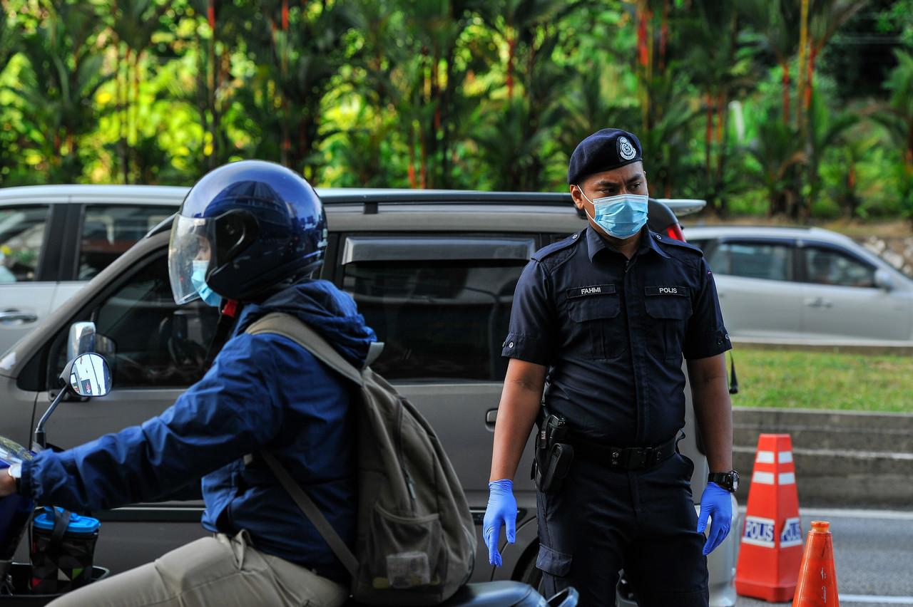 Anggota polis bertugas di sekatan jalan raya di Jalan Kuching menghala ke ibu kota hari ini. Gambar: Bernama