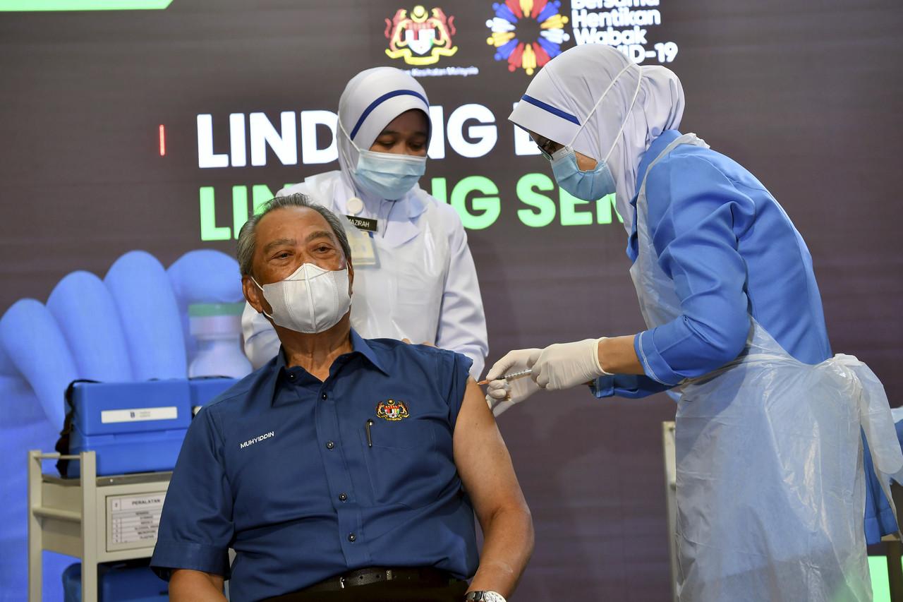 Perdana Menteri Muhyiddin Yassin menjadi individu pertama di negara ini menerima vaksin Covid-19 jenis Pfizer-BioNTech pada Program Imunisasi Covid-19 Kebangsaan di Pusat Kesihatan Daerah Putrajaya, Presint 11, hari ini. Gambar: Bernama