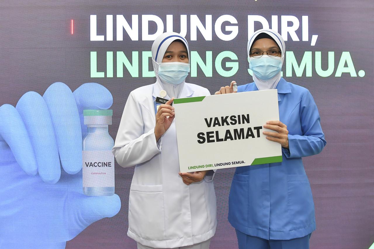Pemberi vaksin kepada Perdana Menteri Muhyiddin Yassin, Lina Ibrahim (kanan) bersama pemberi vaksin kepada Ketua Pengarah Kesihatan Dr Noor Hisham Abdullah, Mazirah Mokhtar selepas majlis pelancaran Program Imunisasi Covid-19 Kebangsaan di Pejabat Kesihatan Daerah Putrajaya Presint 11 semalam.