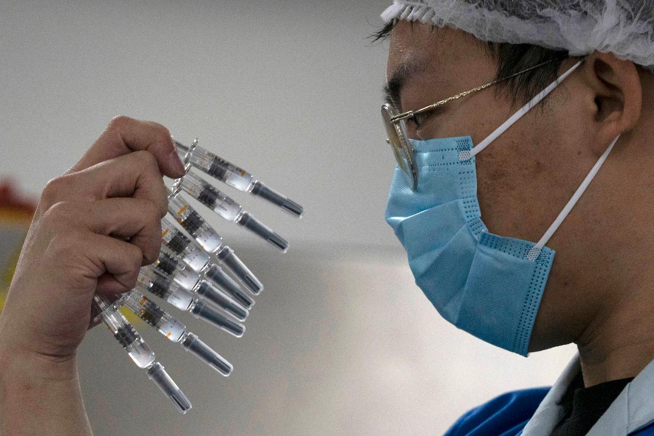 A worker inspects syringes of a vaccine for Covid-19 produced by Sinovac at its factory in Beijing, Sept 24, 2020. China has approved two new more Covid-19 vaccines for wider use, adding to its growing arsenal of shots: one from CanSino Biologics, and a second one from state-owned Sinopharm. Photo: AP