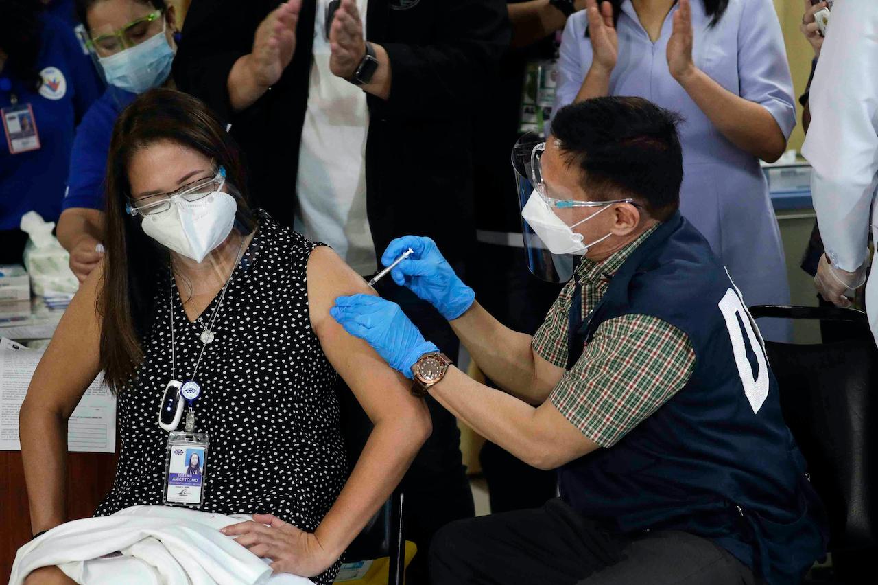 Health Secretary Francisco Duque III (right) administers a dose of China's Sinovac vaccine to a Filipino doctor during the first first batch of vaccinations at the Lung Center of the Philippines in Quezon city, Philippines on, March 1. Photo: AP