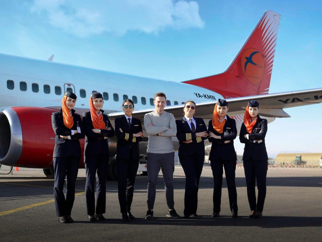 Kam Air's first all-women flight crew pose for a shot in front of their plane with travel blogger Josh Cahill (centre). Photo: Facebook