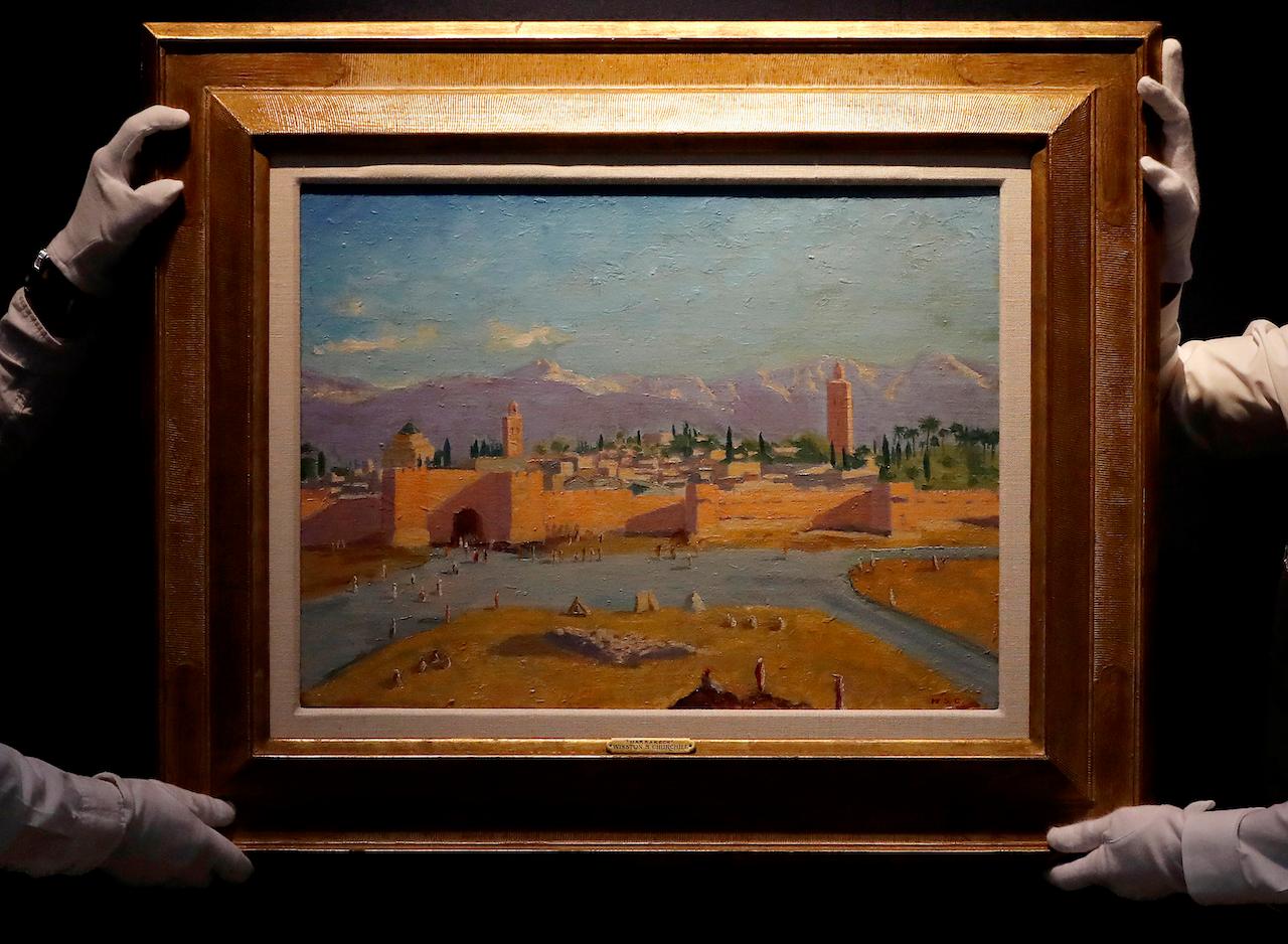 In this photo taken on Feb 17, Christie's employees in London adjust an oil on canvas painting by Winston Churchill painted in January 1943 called 'Tower of the Koutoubia Mosque'. The painting sold at auction on Monday for more than US$11.5 million, smashing the previous record for a work by Britain’s World War II leader. Photo: AP