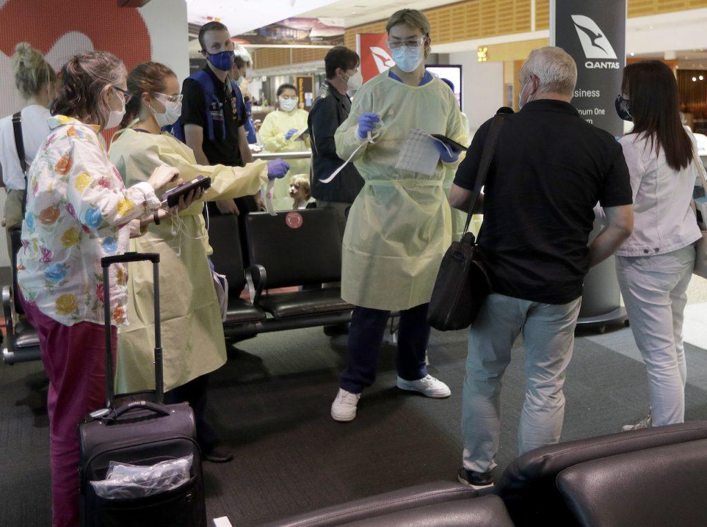 Passengers arriving from Melbourne are screened by health workers at the airport in Sydney, Australia, Feb 12. Australia has extended its ban on international travel another three months, citing the Covid-19 situation ovoerseas. Photo: AP