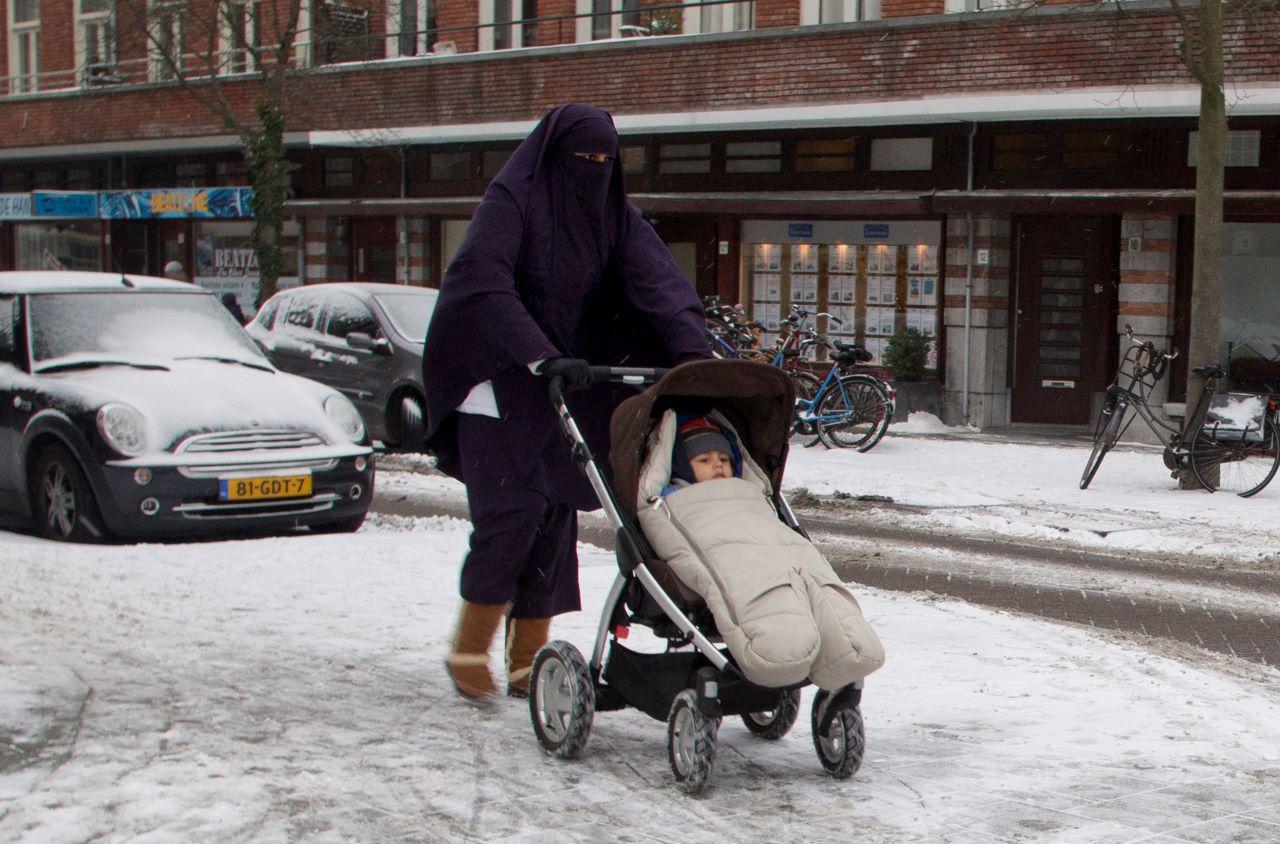 A woman wearing a full-face veil pushes a baby stroller in Amsterdam, Netherlands. Switzerland will vote this weekend on whether to impose a ban on full facial coverings in public places with polls indicating a slim majority in favour of the move. Photo: AP