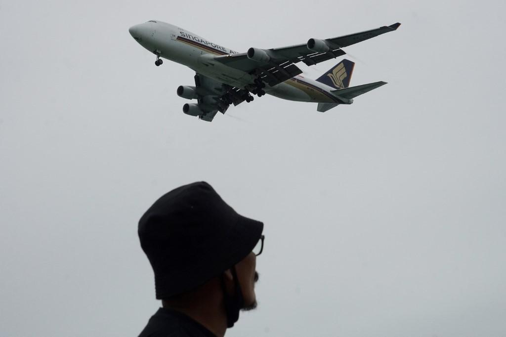 A man watches as a Singapore Airlines plane approaches for landing at Changi International Airport in Singapore, Aug 23, 2020. SIA, which was recently affected by a data breach, says no confidential data can be accessed with the leaked data as additional secure information is still needed to clear the verification process. Photo: AFP