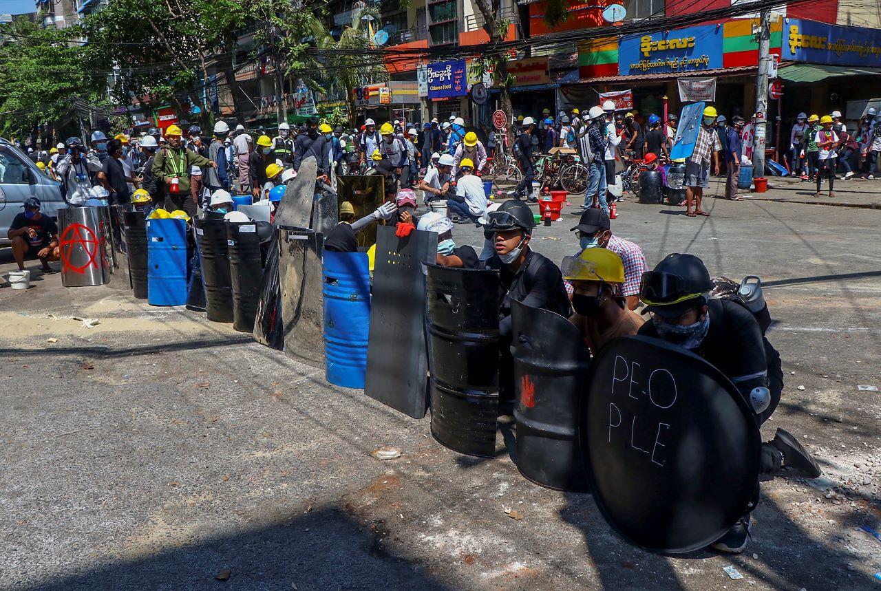 Anti-coup protesters take cover behind makeshift shields during a demonstration in Yangon, Myanmar, March 4. Demonstrators in Myanmar protesting last month's military coup returned to the streets Thursday, undaunted by the killing of at least 38 people the previous day by security forces. Photo: AP