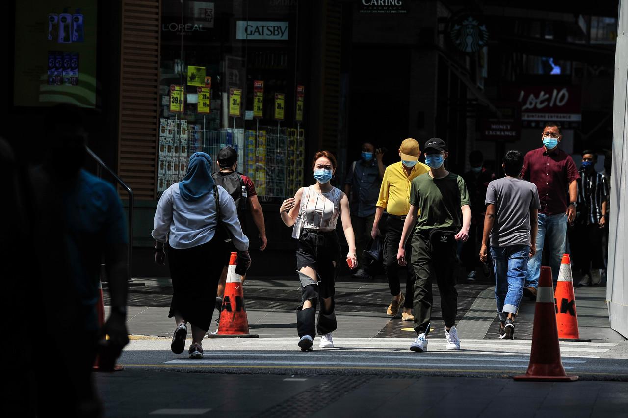 Pedestrians in Kuala Lumpur observe health SOPs including the mandatory use of face masks to curb the spread of Covid-19. Photo: Bernama
