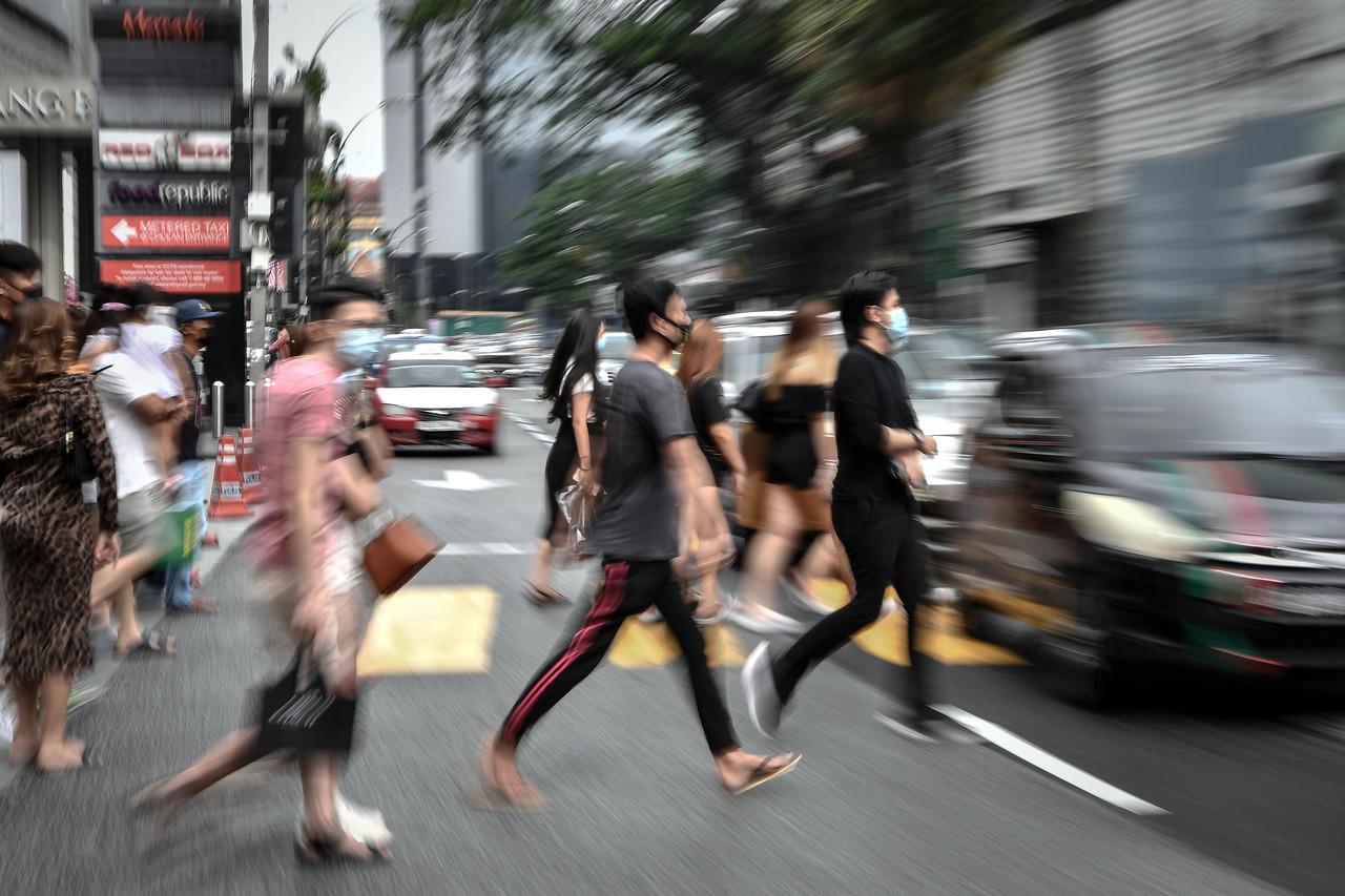 Pedestrians in Kuala Lumpur cross the street while adhering to Covid-19 SOPs including the mandatory use of face masks. Photo: Bernama