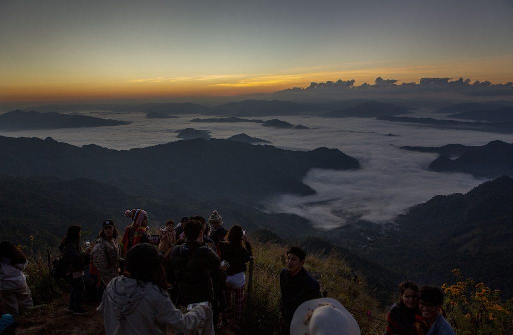 Tourists gather at a mountain viewpoint as the sun rises at Phu Chi Fa viewpoint, Chiang Rai, Thailand on Nov 27. The pandemic has seen the number of tourists on Phuket plummet from around 50,000 a day to just hundreds. Photo: AP