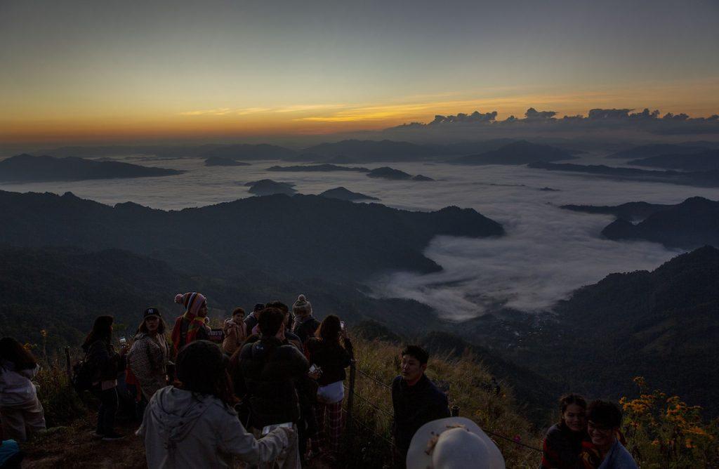 Tourists gather at a mountain viewpoint as the sun rises at Phu Chi Fa viewpoint, Chiang Rai, Thailand on Nov 27. The pandemic has seen the number of tourists on Phuket plummet from around 50,000 a day to just hundreds. Photo: AP
