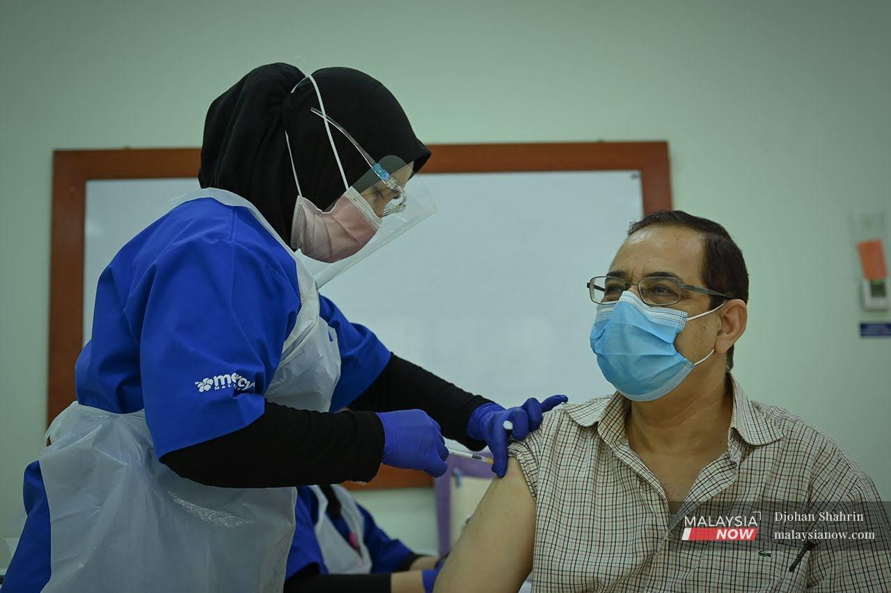 Pegawai perubatan memberi suntikan vaksin untuk fasa pertama dalam Program Imunisasi Covid-19 Kebangsaan.