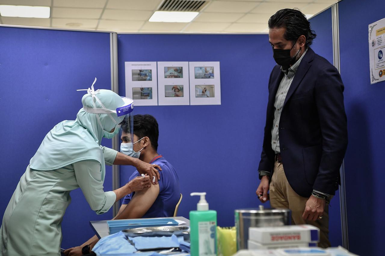 Khairy Jamaluddin, who is in charge of the country's vaccination programme, watches as a nurse administers a shot of Pfizer-BioNTech vaccine to a frontliner at the Universiti Malaya Medical Centre vaccination centre in Petaling Jaya today. Photo: Bernama