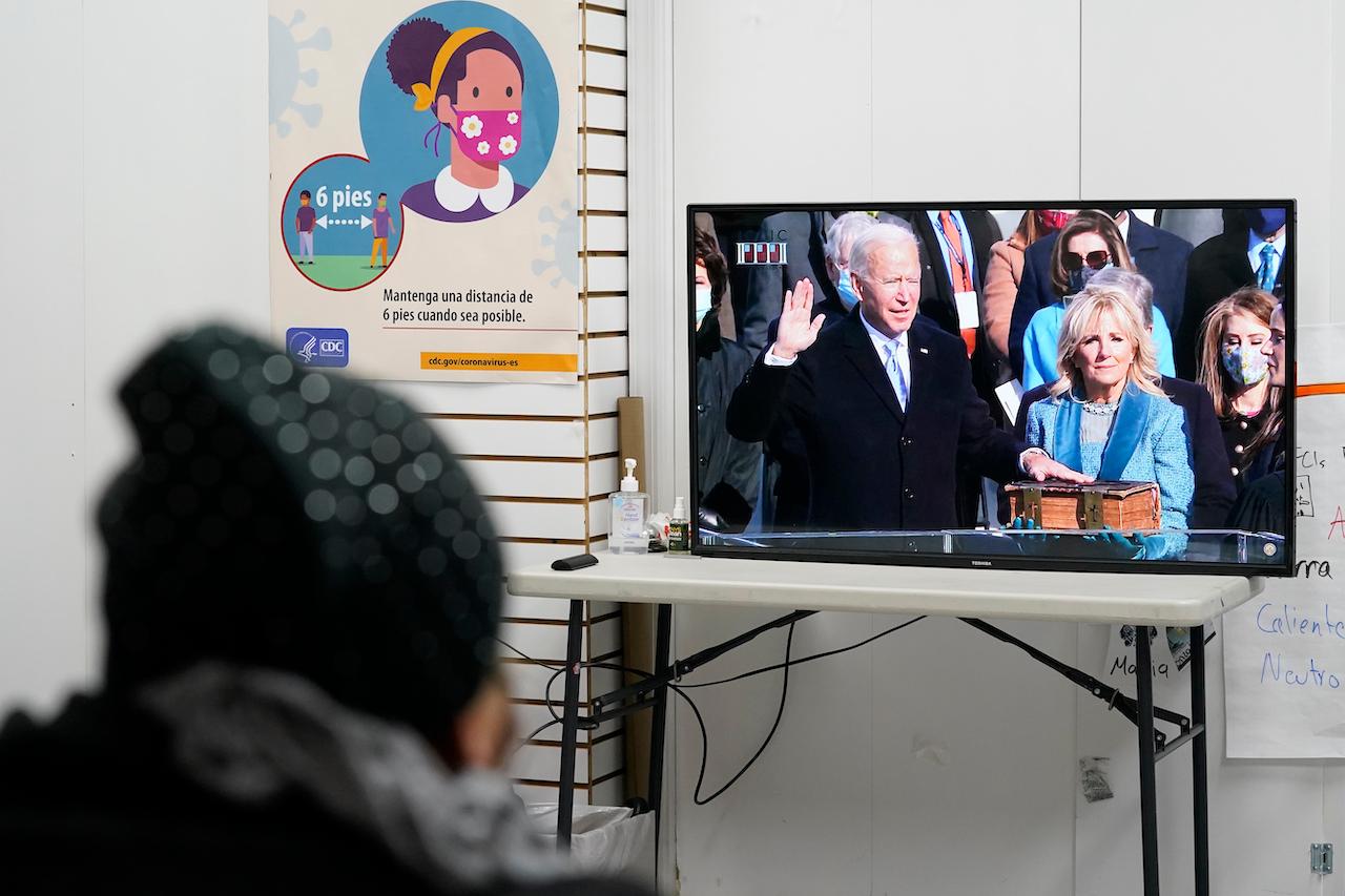 A woman at an immigrants rights organisation in Brooklyn, New York, watches as President Joe Biden takes the oath of office during his swearing-in ceremony on Jan 20. Photo: AP