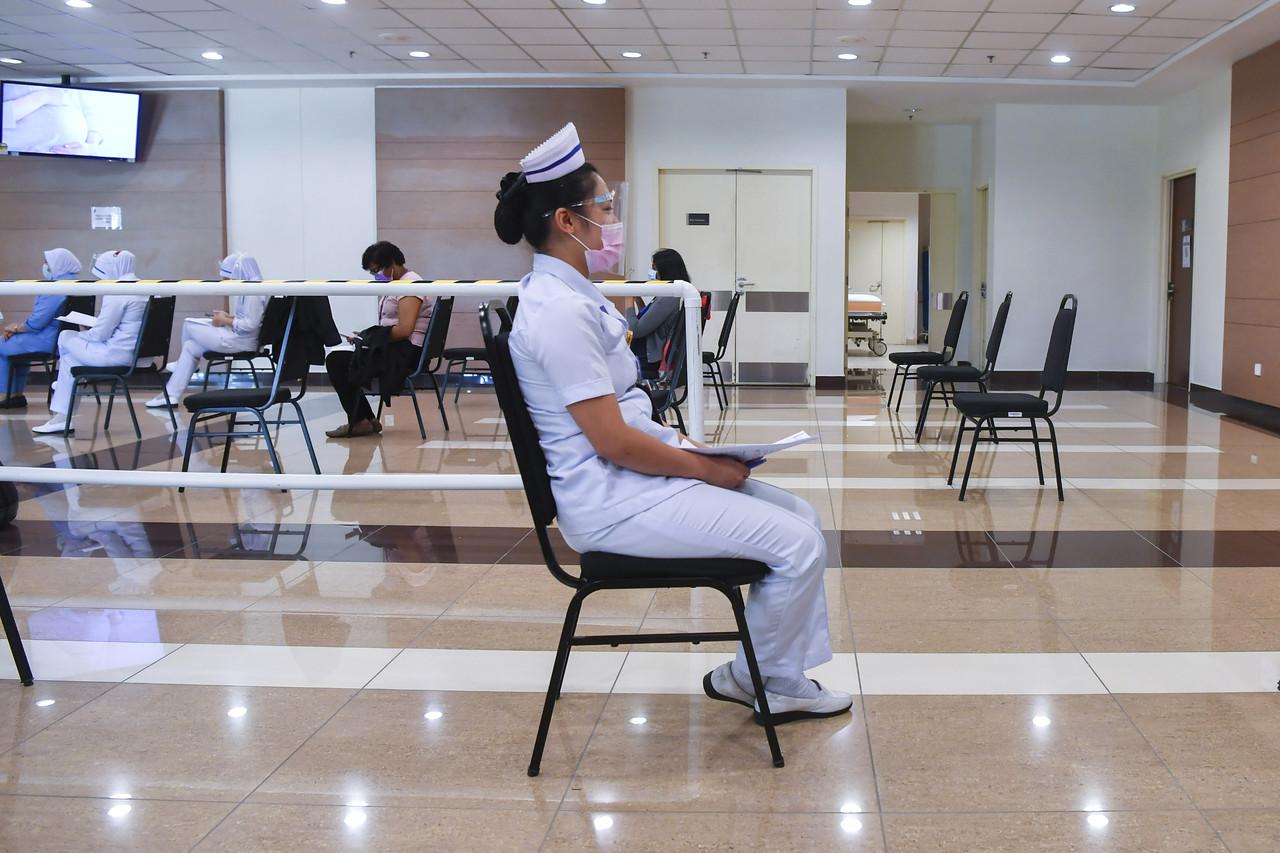 A nurse at the National Cancer Institute waits to receive her first dose of the Pfizer-BioNTech vaccine under the national immunisation programme. Photo: Bernama