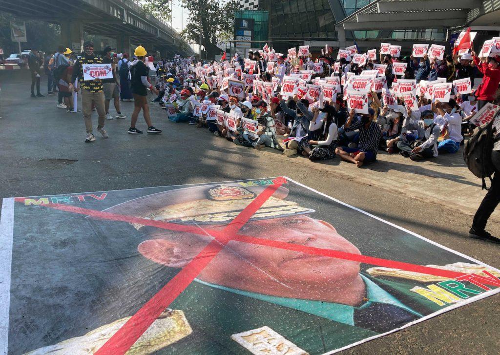 An image showing an X mark on the face of General Min Aung Hlaing lies on a road as anti-coup protesters gather outside the Hledan Centre in Yangon, Myanmar, Feb 14. Two of Min Aung Hlaing's children have been blacklisted by the US in response to the military’s coup and the killing of protesters. Photo: AP