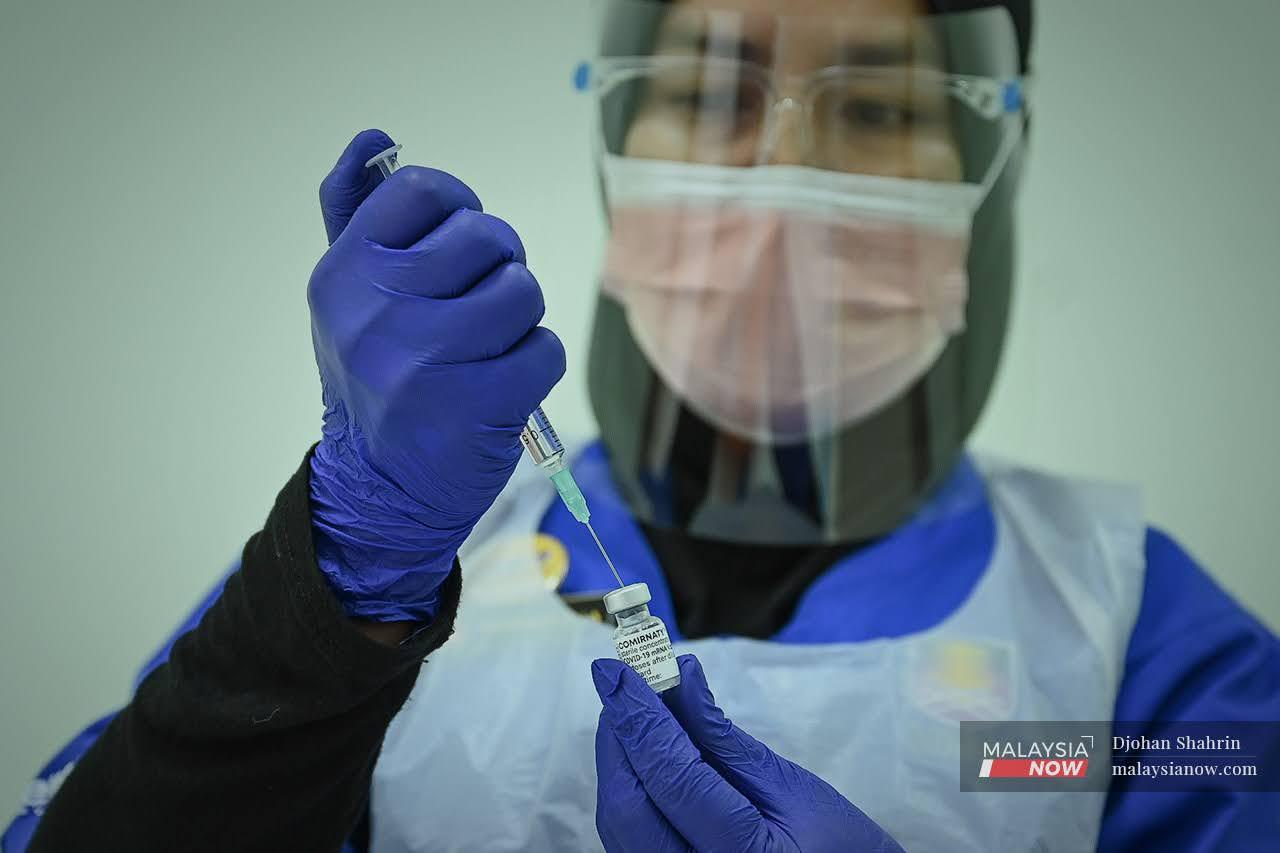 A nurse prepares a syringe of Pfizer-BioNTech vaccine to be administered to frontliners under the national immunisation programme. The estimated death toll of 3,000 nurses killed by Covid-19 in 60 countries is thought to be a gross underestimate of the full total.