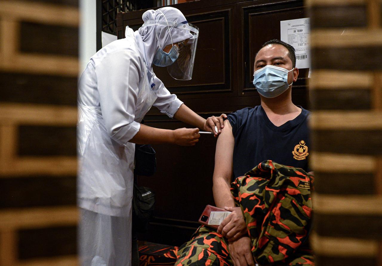 A frontliner from the Fire and Rescue Department receives his first dose of the Pfizer-BioNTech vaccine at Sunway Pyramid Convention Centre in Petaling Jaya today. Photo: Bernama