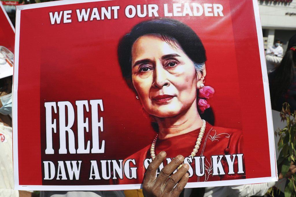 An anti-coup protester holds up a poster showing an imaged of Aung San Suu Kyi and a sign that reads 'We Want our Leader. Free Daw Aung San Suu Kyi', during a rally near the Mandalay Railway Station in Mandalay, Myanmar, Feb 22. Photo: AP