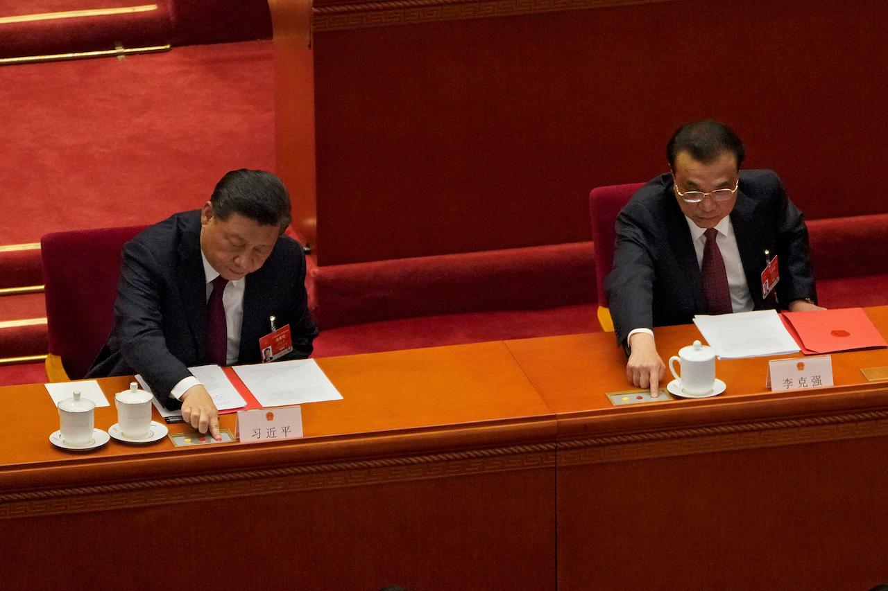 Chinese President Xi Jinping (left) and Premier Li Keqiang cast their vote during the closing session of the National People's Congress at the Great Hall of the People in Beijing, March 11. China's ceremonial legislature on Thursday endorsed the ruling Communist Party's latest move to tighten control over Hong Kong by reducing the role of its public in picking the territory's leaders. Photo: AP