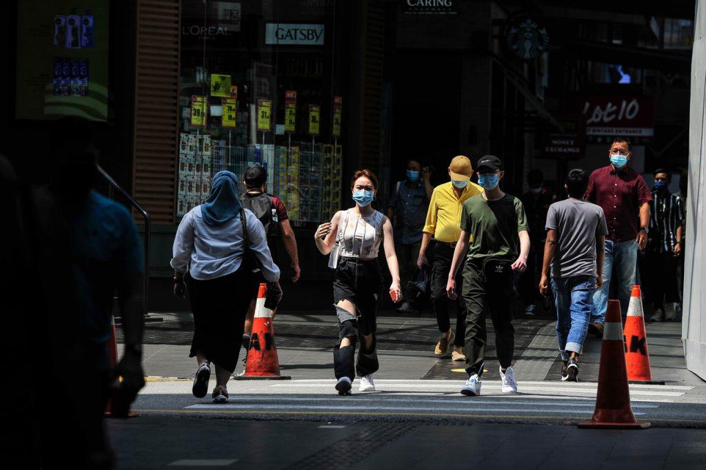 SOPs such as wearing face masks, observing physical distancing and scanning temperatures before entering premises are mandatory under the country's movement restrictions. Photo: Bernama