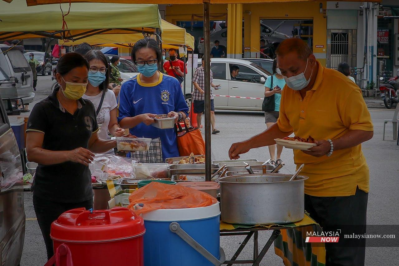 Orang ramai membeli makanan di pasar malam selepas PKPB membenarkan ia dibuka.