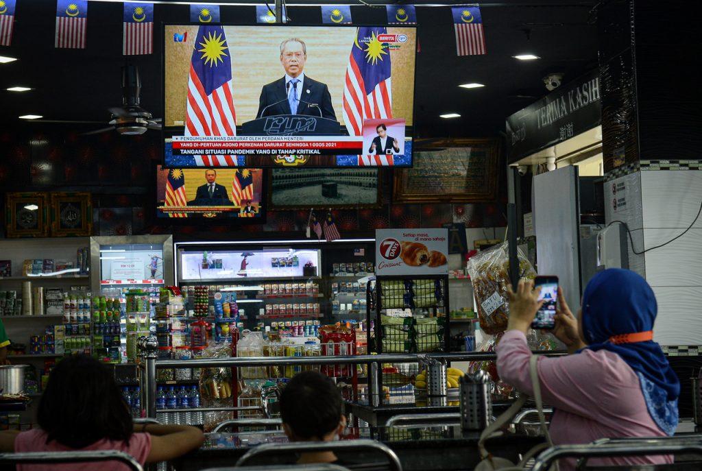 Customers at an eatery in Kuala Lumpur watch Prime Minister Muhyiddin Yassin's live address on the state of emergency aired following the Agong's announcement on Jan 12. Under the emergency ordinance, the maximum compound imposed on those who breach health SOPs has been raised from RM1,000 to RM10,000. Photo: Bernama