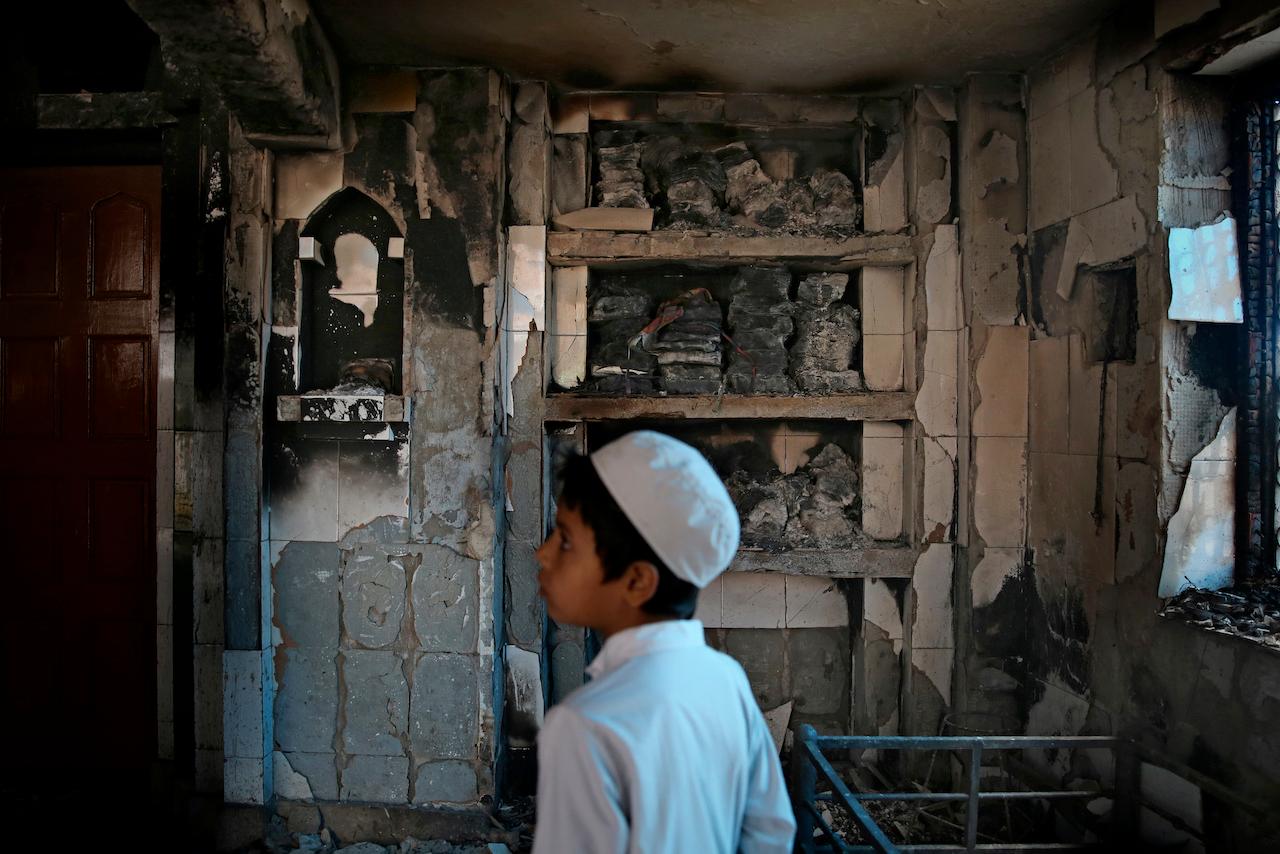 An Indian Muslim boy stands inside a mosque burnt during communal violence in New Delhi, India, on Feb 27, 2020. In Uttar Pradesh, there has been an increase in recent years of reported targeted attacks on minorities, including Muslims, by 'extremist Hindu groups'. Photo: AP