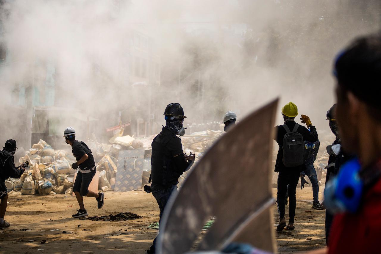Anti-coup protesters scatter during the ongoing police crackdown during a protest in Sanchaung township, Yangon, Myanmar, on March 14. A number of people were shot dead during protests in Myanmar's largest city on Sunday, as security forces continued their violent crackdown against dissent following last month's military coup. Photo: AP
