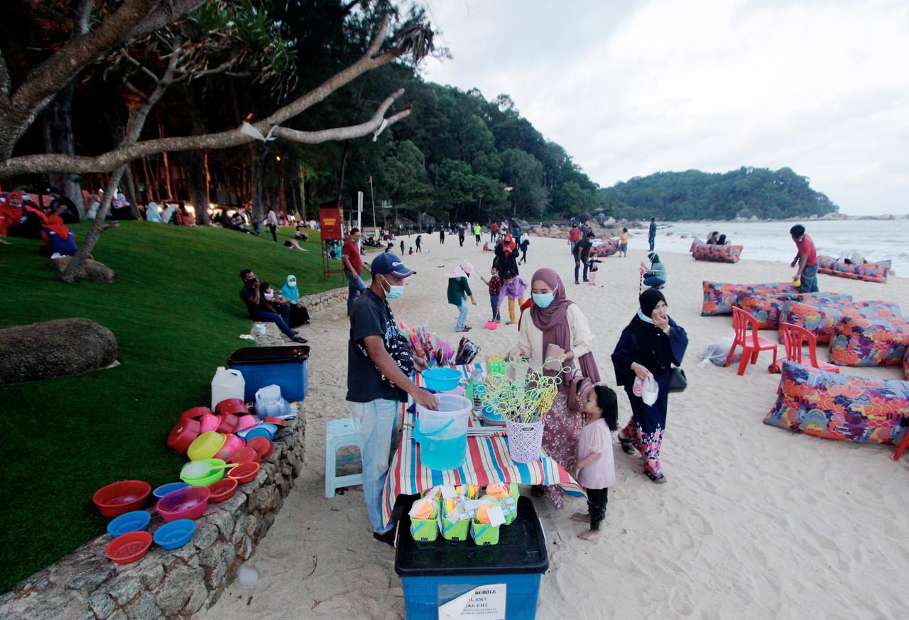 A vendor sells soap bubble rings and mix at Pantai Teluk Cempedak, a popular tourist destination in Kuantan, Pahang. Pahang is one of several states under recovery movement control order which were recently given the green light for interstate tourism travel under tight restrictions. Photo: Bernama