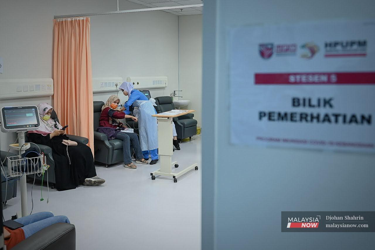 A healthcare worker monitors the condition of several women who received their first Covid-19 jab at Hospital Pengajar Universiti Putra Malaysia in Serdang, Selangor.