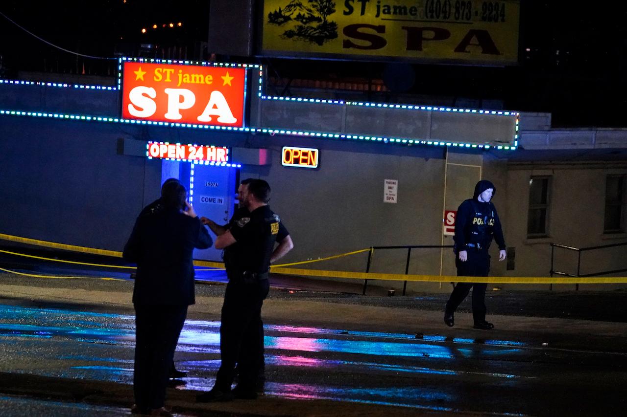 Law enforcement officials confer outside a massage parlor following a shooting on March 16, in Atlanta. Shootings at two massage parlors in Atlanta and one in the suburbs have left multiple people dead, many of them women of Asian descent, authorities said. Photo: Ap