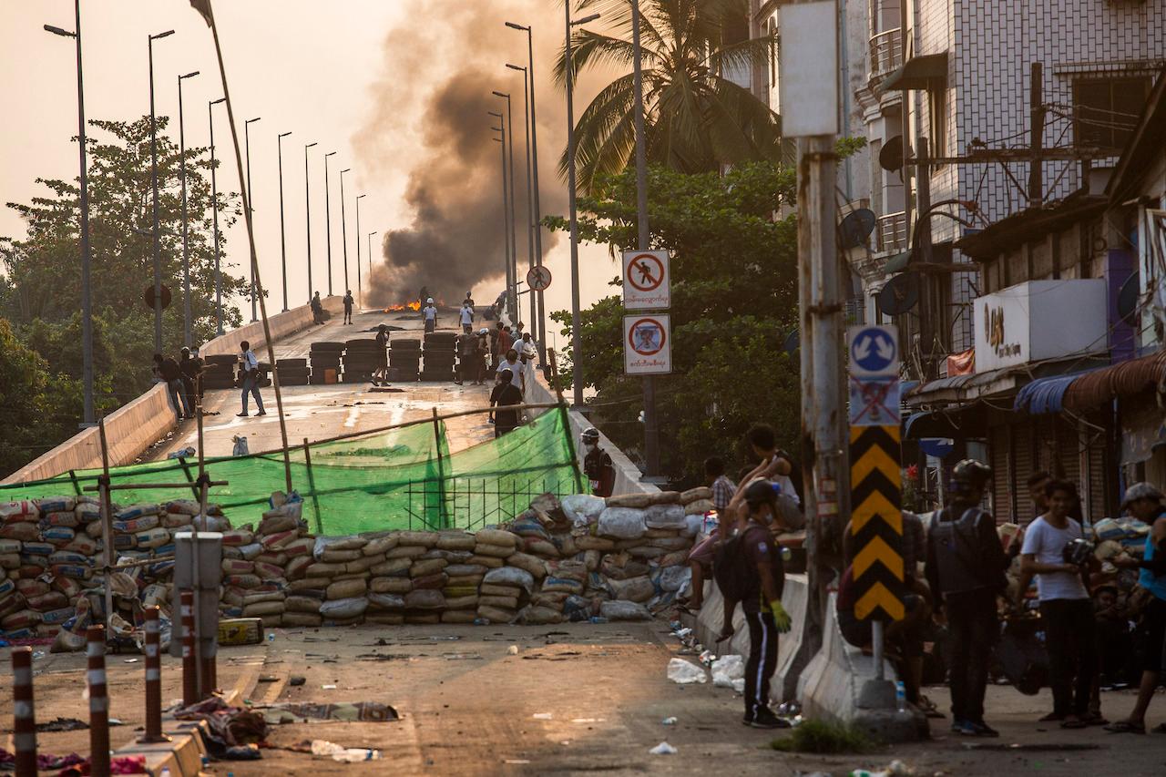 Protesters take positions on Bayint Naung Bridge, blocked with an improvised barricade to prevent Myanmar security forces from crossing, as smoke rises from burning tyres in Yangon, Myanmar, March 17. The country has been in uproar since the military ousted civilian leader Aung San Suu Kyi in a Feb 1 coup, triggering a mass uprising that has brought hundreds of thousands to the streets demanding a return to democracy. Photo: AP
