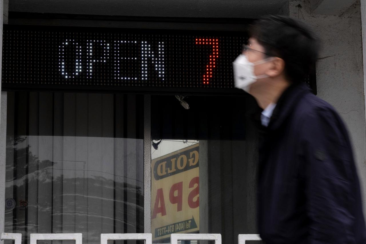 A man walks past the front of the Gold Spa massage parlor in Atlanta on March 17, the day after multiple people were killed at three massage spas in the Atlanta area. Photo: AP