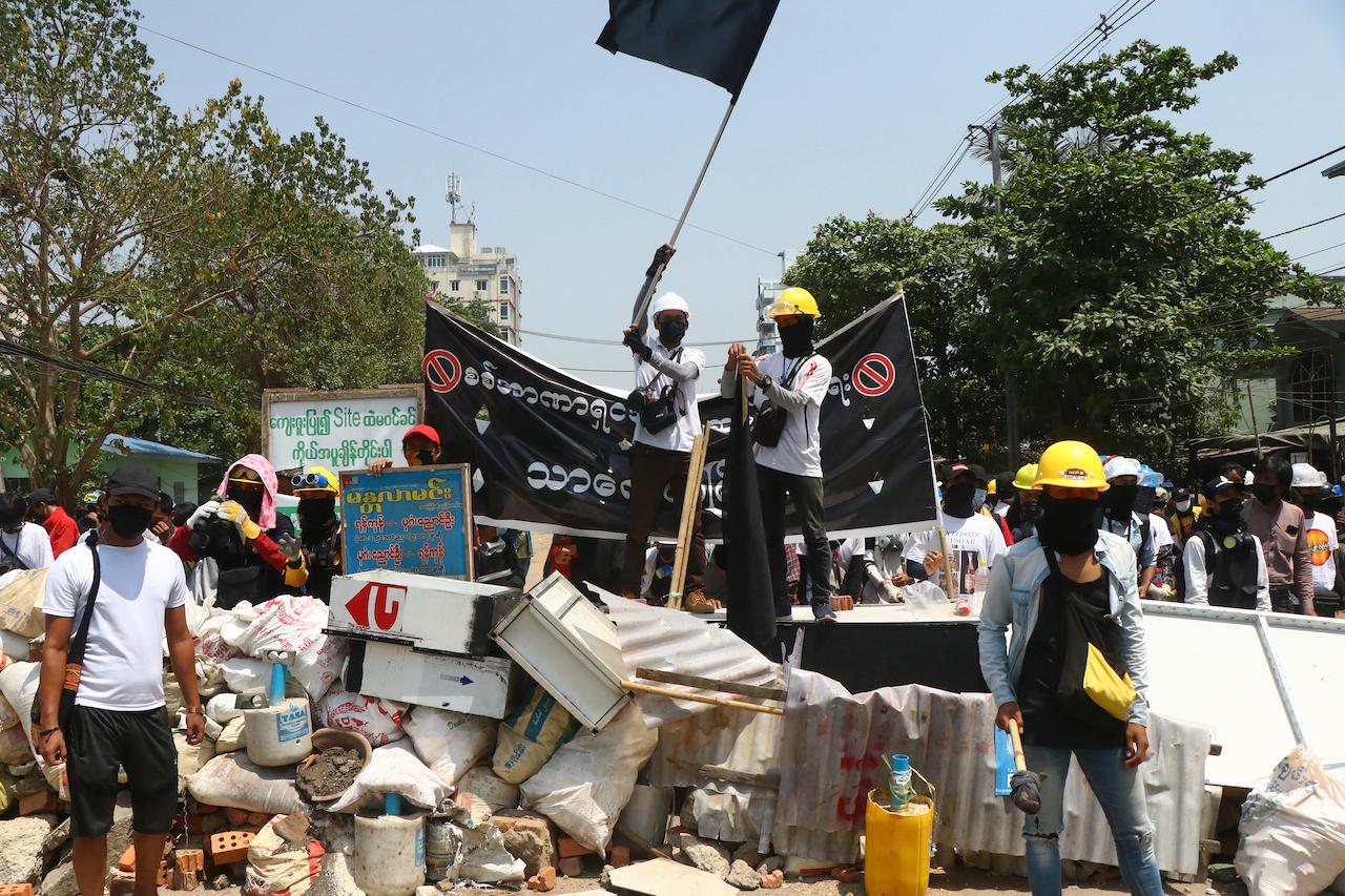 Protesters prepare to defend themselves as they gather in Tarkata township, Yangon, Myanmar, March 20. Barricades have become something of a protester trademark, blocking main roads and employing everything from sand-filled cement bags and bamboo screens to large, wheely garbage bins and housing bricks. Photo: AP