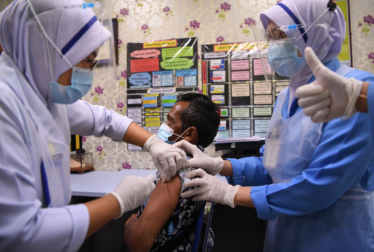 An Orang Asli leader receives his first dose of the Pfizer-BioNTech vaccine at the Jerantut district health centre in Kuantan, Pahang today. He is one of the 50 earliest Orang Asli in the state to receive the jab. Photo: Bernama