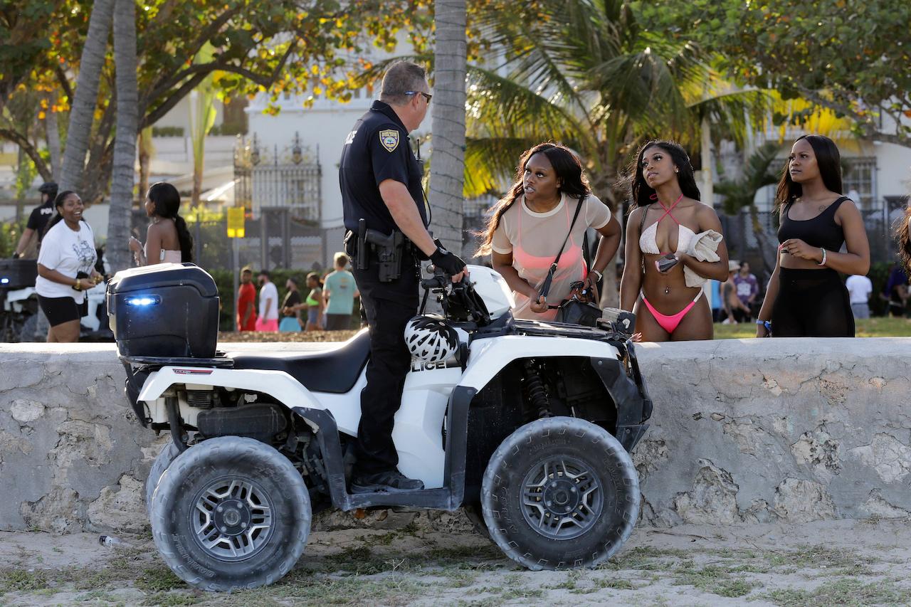 University students talk with a Miami Beach police officer in Florida in this March 14, 2020 file photo. Visitors have been ordered off the streets and restaurants told to close at 8pm in South Beach following an increase of violence and vandalism over recent days. Photo: AP
