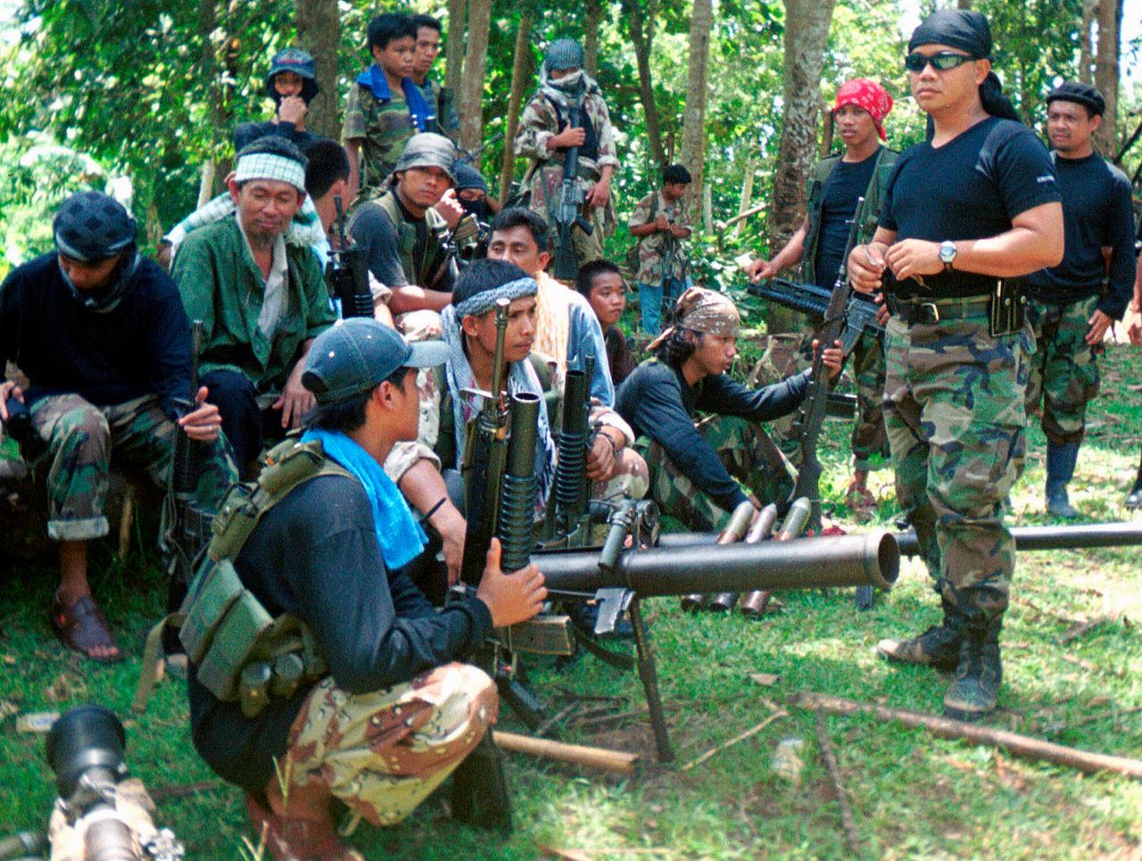 In this undated file photo, Abu Sayyaf spokesman Abu Sabaya (front, right) is seen with his band of armed extremists. Philippine troops captured an Abu Sayyaf rebel commander blamed for years of ransom kidnappings and on March 21, rescued the last of his four Indonesian captives, the military said. Photo: AP