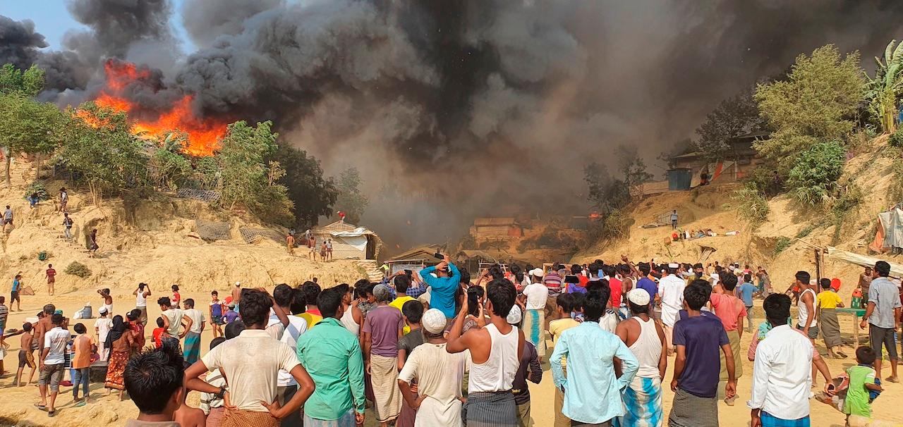 Rohingya refugees watch smoke rising following a fire at the Rohingya refugee camp in Balukhali, southern Bangladesh, March 22. The fire destroyed hundreds of shelters and left thousands homeless, officials and witnesses said. Photo: AP