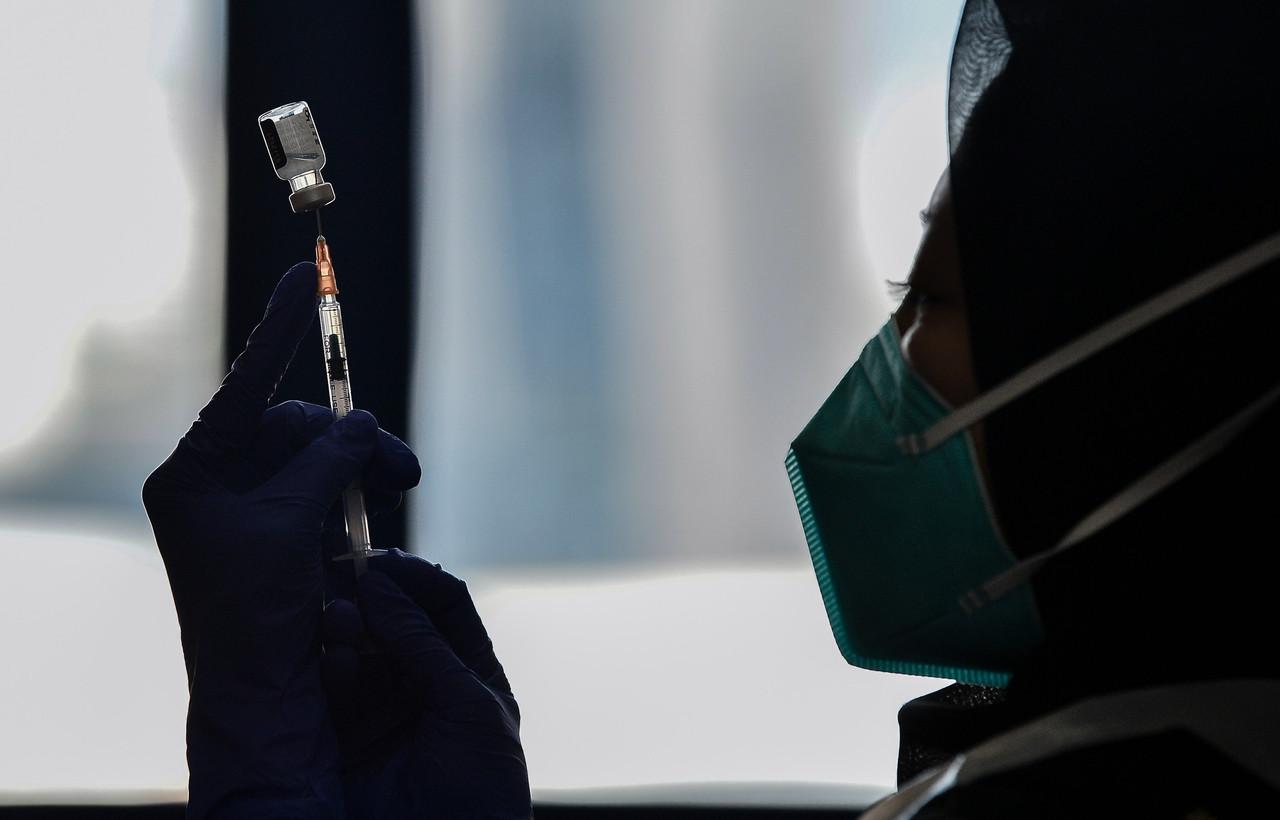 A nurse prepares a syringe of Pfizer-BioNTech vaccine to be administered to frontliners under the first phase of the national immunisation programme. Photo: Bernama