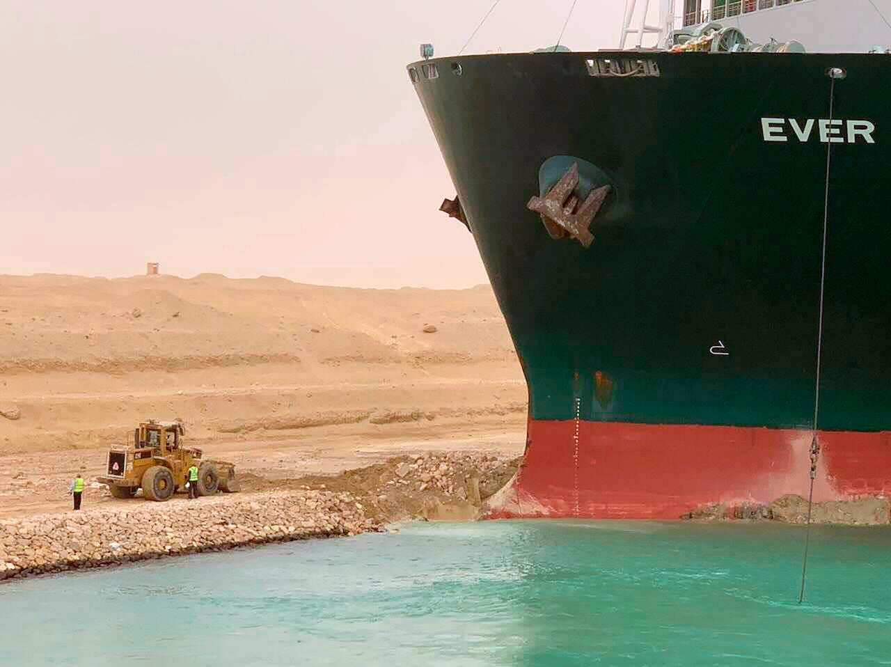In this photo released by the Suez Canal Authority, cargo ship Ever Given sits with its bow stuck into the wall after it became wedged across Egypt’s Suez Canal on March 24, blocking all traffic in the vital waterway. Photo: AP