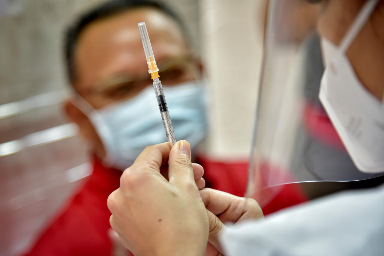 A health worker in Labuan prepares a syringe of Pfizer-BioNTech vaccine to be administered under the first phase of the national vaccination programme. Photo: Bernama