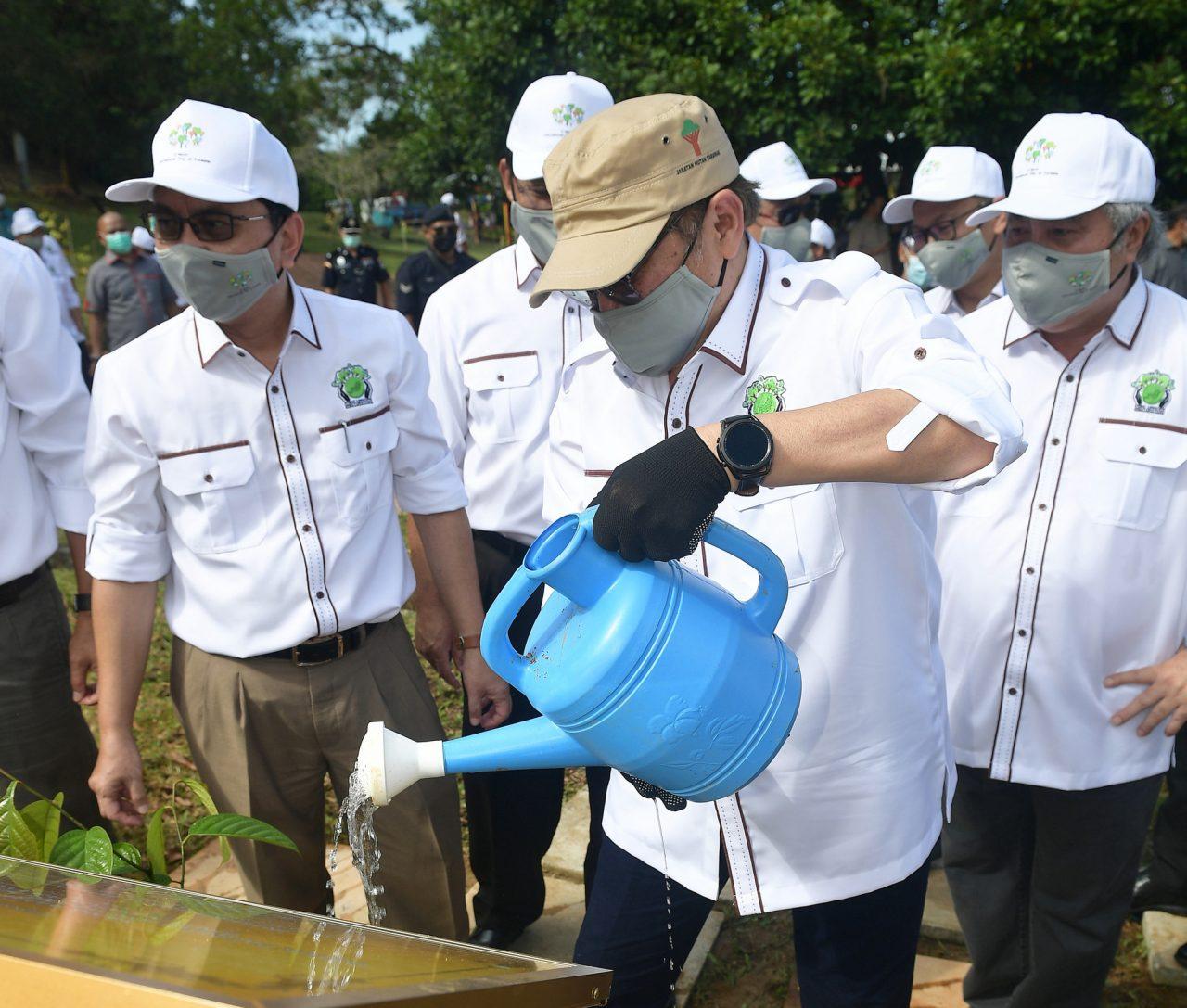Sarawak Chief Minister Abang Johari Openg (second right) waters a plant at the state-level celebration of International Forest Day in Kuching today. With him is his deputy Awang Tengah Ali Hasan (right). Photo: Bernama