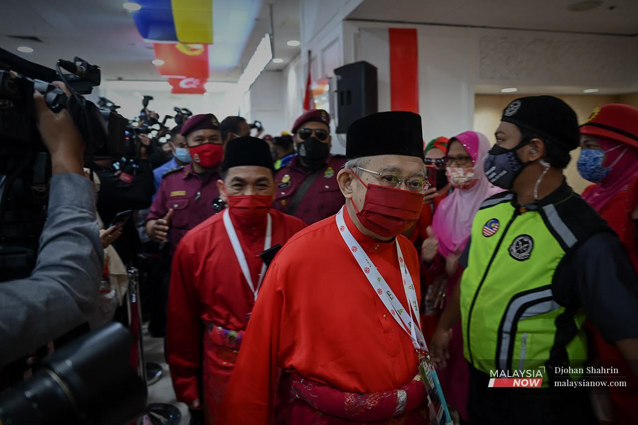 Tengku Razaleigh Hamzah berjalan keluar selepas mendengar ucapan dasar Presiden Umno, Ahmad Zahid Hamidi.