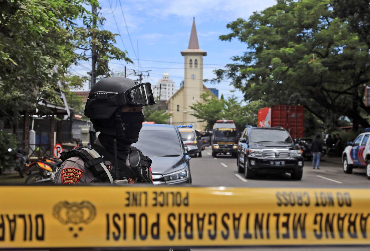 A police officer stands guard near a church where an explosion went off in Makassar, South Sulawesi, Indonesia, March 28. Photo: AP