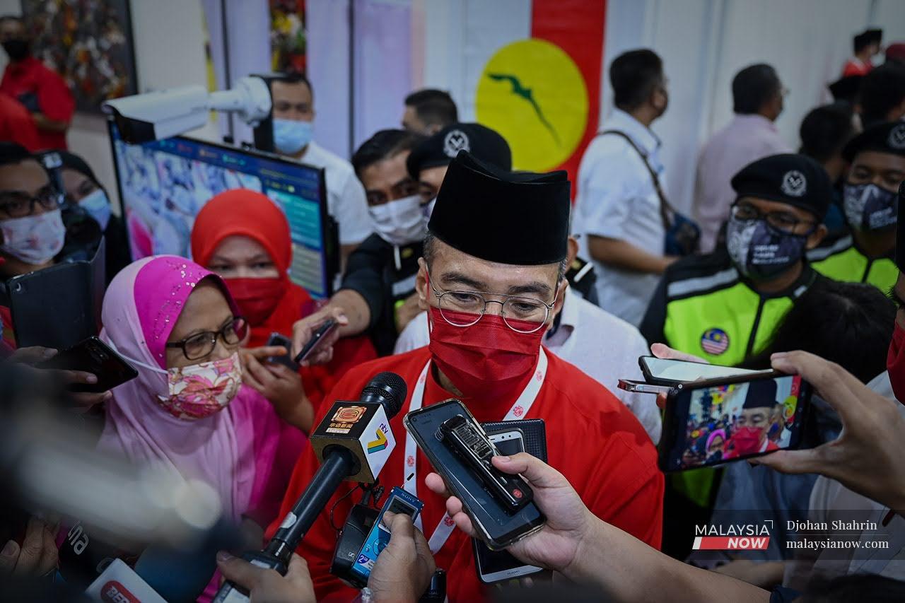 Hishamuddin Tun Hussein berkata sesuatu kepada media ketika berjalan keluar selepas mendengar ucapan dasar presiden Umno.