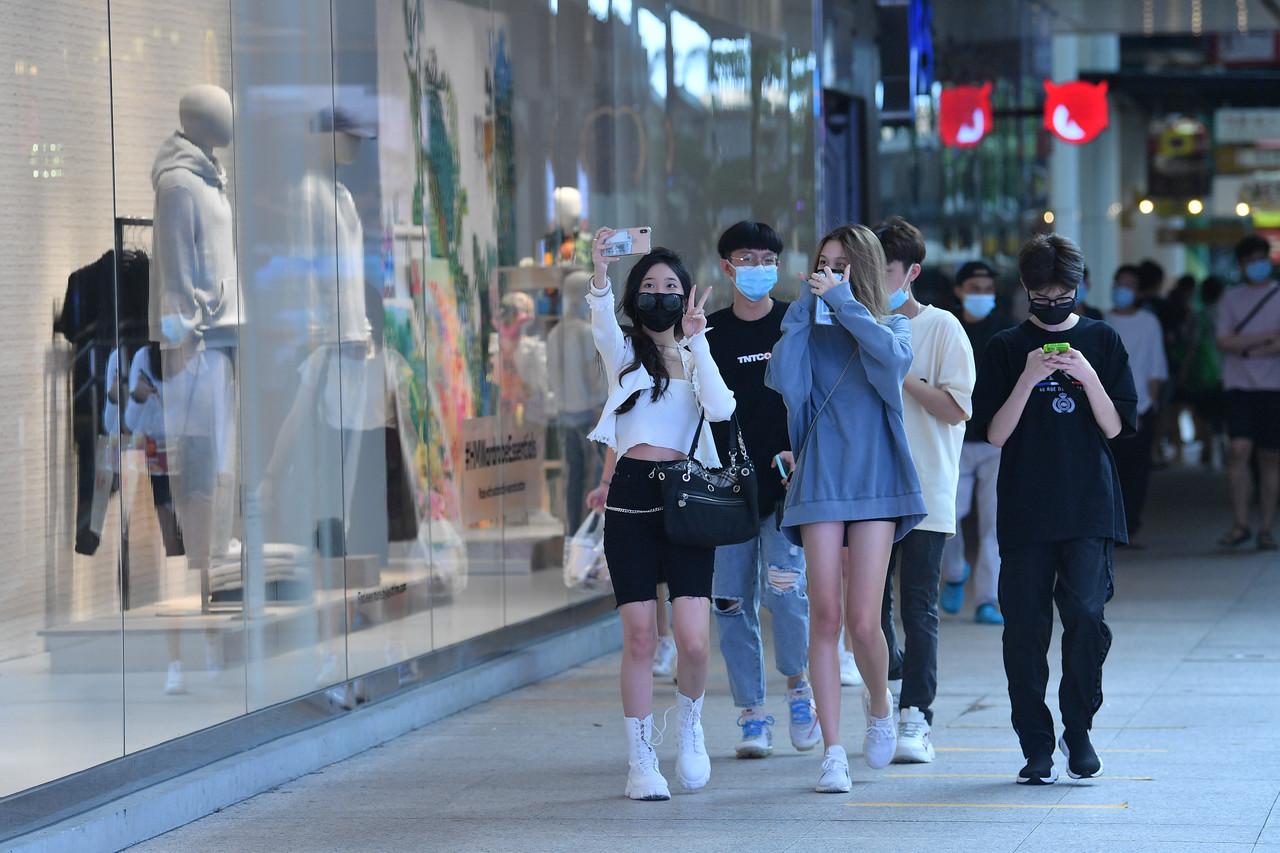 A group of youngsters wearing face masks pose for a wefie while strolling through downtown Kuala Lumpur during the conditional movement control order period. Photo: Bernama