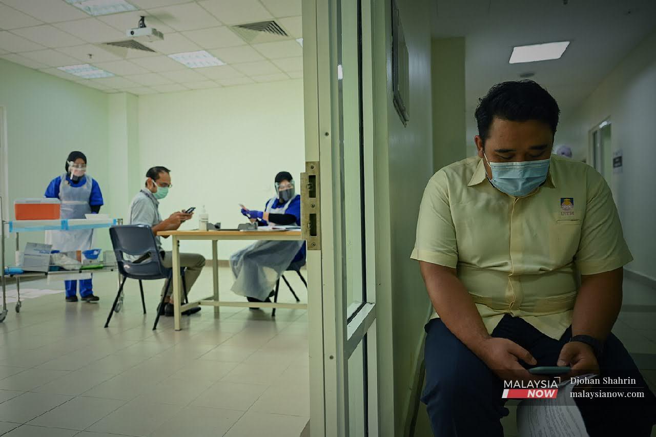 Seorang petugas barisan hadapan Hospital Universiti Teknologi Mara (UiTM) menunggu gilirannya untuk menerima suntikan Vaksin Pfizer-BioNTech.